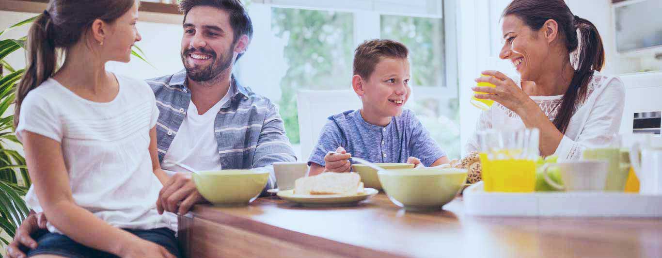 A happy family sits around the breakfast table